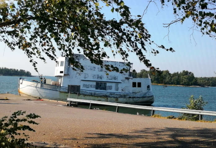 Vanhasta troolarista rakennettu, huonokuntoinen alus on irvokas näky Aidanpäänniemen idyllisessä merimaisemassa.